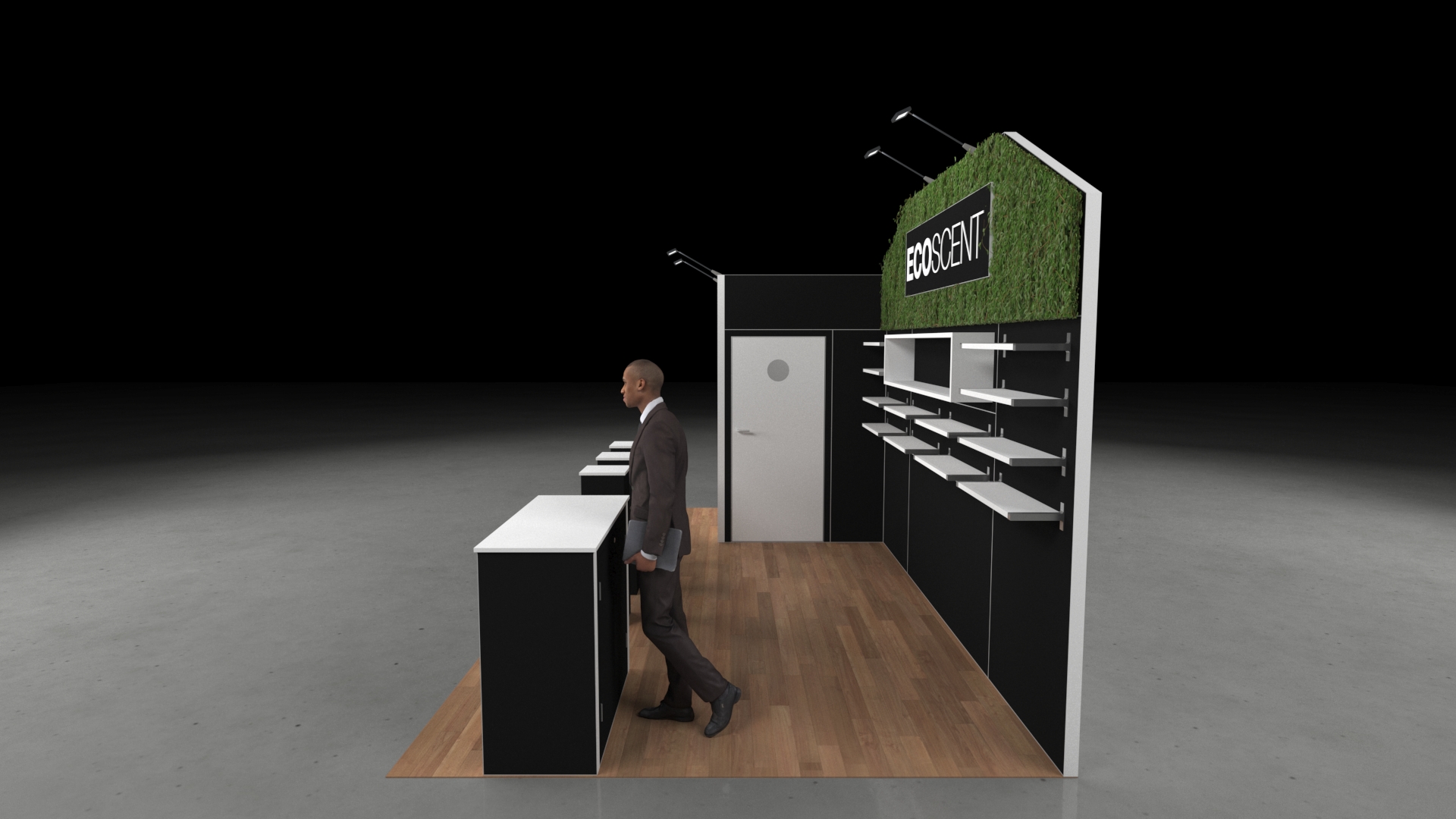 A 6x3 metre exhibition stand. The design features a large central green wall backdrop and a prominent reception counter. The stand incorporates multiple product shelving units and three black presentation plinths.